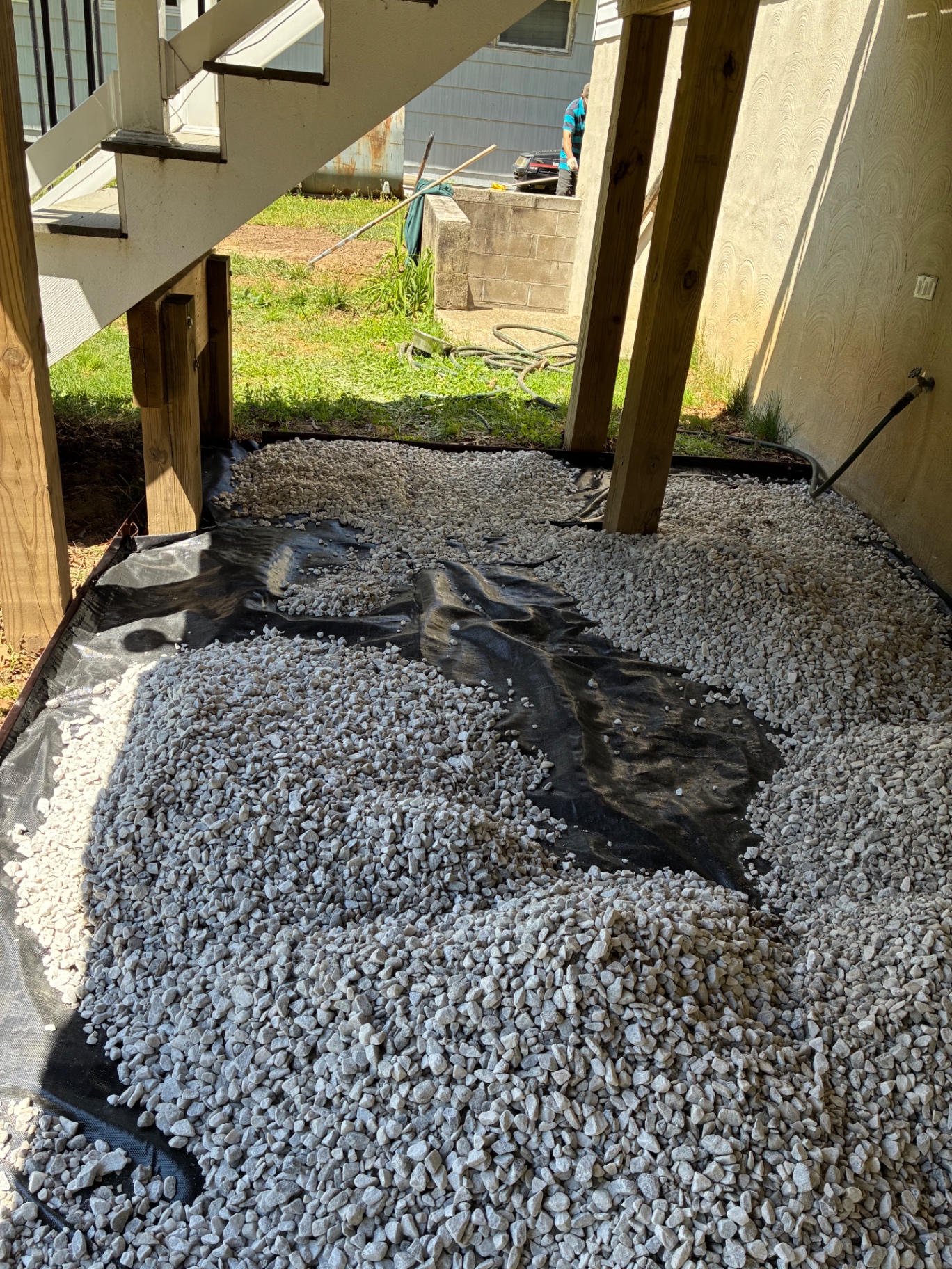 Gravel and landscape fabric drainage area under a deck